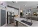 Spacious kitchen showcasing stainless steel fridge, white cabinets, island with sink and pendant lights at 3605 Wild Blossom Pl, Parrish, FL 34219