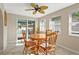 Cozy dining area with a ceiling fan, tile flooring, and sliding doors to the pool at 3672 Pine Rd, Venice, FL 34293