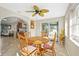Bright dining area with a round wooden table and chairs, illuminated by natural light at 3672 Pine Rd, Venice, FL 34293