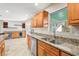 Open kitchen area featuring stone countertops, stainless steel appliances, and custom wood cabinets at 3672 Pine Rd, Venice, FL 34293