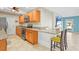 Well-equipped kitchen featuring wood cabinetry, granite countertops, and a breakfast bar at 3672 Pine Rd, Venice, FL 34293