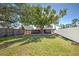 Expansive backyard featuring lush grass and a large shade tree, surrounded by a privacy fence at 470 Leach St, Englewood, FL 34223