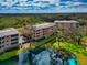 Stunning aerial view of multi-story condos, mature trees, and tranquil water feature at 5246 Manorwood Dr # 4, Sarasota, FL 34235