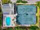 A high angle of the pool and tennis courts with building next to them and foliage at 5246 Manorwood Dr # 4, Sarasota, FL 34235
