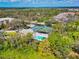 Aerial view showcasing the community pool, tennis courts and lush surrounding greenery at 5246 Manorwood Dr # 4, Sarasota, FL 34235