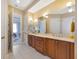 Bathroom featuring a double vanity with wood cabinetry, a soaking tub, and multiple doors at 5246 Manorwood Dr # 4, Sarasota, FL 34235