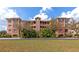 Full exterior shot of the complex, landscaped with mature palm trees and green grass at 5246 Manorwood Dr # 4, Sarasota, FL 34235