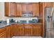 A kitchen featuring granite counters, stainless steel refrigerator, and wooden cabinets at 5246 Manorwood Dr # 4, Sarasota, FL 34235
