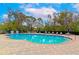 Large pool surrounded by ample seating, a safety fence, and clear blue skies at 5246 Manorwood Dr # 4, Sarasota, FL 34235