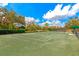 Pristine tennis court with full net, shadowed with trees and open sky at 5246 Manorwood Dr # 4, Sarasota, FL 34235