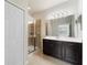 Bathroom featuring a glass enclosed shower and a dark vanity with a large mirror at 5435 Soapstone Place # 22-103, Sarasota, FL 34233