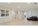 Bright living room with ceramic tile floors, staircase and dark brown leather ottoman at 5435 Soapstone Place # 22-103, Sarasota, FL 34233