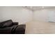 Bright living room with ceramic tile floors, a white door and a brown leather ottoman at 5435 Soapstone Place # 22-103, Sarasota, FL 34233