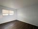 Bedroom with dark wood-look floors and a window letting in natural light at 6024 Arlene Way, Bradenton, FL 34207