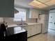 Bright kitchen featuring stainless steel oven, double sink, tiled backsplash, and white cabinets at 6024 Arlene Way, Bradenton, FL 34207