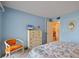 Bright bedroom featuring light blue walls, a mirrored dresser, and an orange accent chair at 6116 43Rd W St # 204D, Bradenton, FL 34210