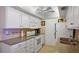 Kitchen includes white cabinets, white appliances, tan counter tops, and stainless steel sink at 6116 43Rd W St # 204D, Bradenton, FL 34210