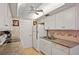 Kitchen includes white cabinets, white appliances, tan counter tops, and stainless steel sink at 6116 43Rd W St # 204D, Bradenton, FL 34210