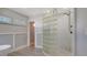 Shower with glass block and stone flooring along with plank accent wall and window at 619 Buttonwood Dr, Longboat Key, FL 34228