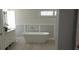 Bright bathroom features a freestanding tub and dual sink vanity with plank accent wall and tiled flooring at 619 Buttonwood Dr, Longboat Key, FL 34228