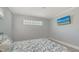Serene bedroom with leaf patterned comforter, neutral walls, plank flooring and bright windows at 619 Buttonwood Dr, Longboat Key, FL 34228