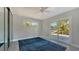Bright bedroom with a ceiling fan, blue rug, and sliding glass doors to the outside at 619 Buttonwood Dr, Longboat Key, FL 34228
