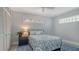 Cozy bedroom with leaf patterned comforter, bedside table, plank walls, and bright windows at 619 Buttonwood Dr, Longboat Key, FL 34228