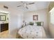 This bedroom features a view into the bathroom, ceiling fan, and a window allowing natural light and refreshing the space at 649 S Tamiami Trl # 210, Venice, FL 34285