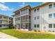 Condo building exterior features screened balconies, well-maintained landscaping, and neutral paint at 649 S Tamiami Trl # 210, Venice, FL 34285