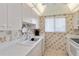 Galley kitchen offers bright cabinets, tile floor, and good storage at 649 S Tamiami Trl # 210, Venice, FL 34285