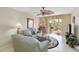 Cozy living room with tile floors, ceiling fan, comfortable furniture, and a sliding glass door to the balcony at 649 S Tamiami Trl # 210, Venice, FL 34285