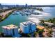 Aerial view of waterfront community, featuring a building, pool, and yacht harbor with many boats at 650 Golden Gate Pt # 403, Sarasota, FL 34236