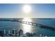 Expansive aerial view showcasing a stunning coastline, a long bridge, and modern buildings against a sunny sky at 650 Golden Gate Pt # 403, Sarasota, FL 34236