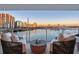 Balcony seating with marina view featuring comfortable chairs, small table, and city skyline in the background at 650 Golden Gate Pt # 403, Sarasota, FL 34236