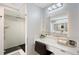 Bright bathroom featuring glass shower, vanity area, and unique tile work at 650 Golden Gate Pt # 403, Sarasota, FL 34236