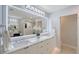 Bright bathroom featuring a double vanity, marble countertops, and glass-enclosed shower at 650 Golden Gate Pt # 403, Sarasota, FL 34236