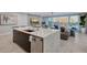 Spacious kitchen with an island, marble countertops, and waterfront views from the living room at 650 Golden Gate Pt # 403, Sarasota, FL 34236