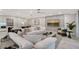 Modern living room with a large white sofa, stylish decor, and a large TV displaying a beach scene at 650 Golden Gate Pt # 403, Sarasota, FL 34236