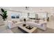Bright open-plan living room featuring sleek white kitchen, comfortable seating, and view of the outdoors at 650 Golden Gate Pt # 403, Sarasota, FL 34236