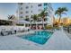 Exterior pool area featuring lounge chairs and a modern building with palm trees at 650 Golden Gate Pt # 403, Sarasota, FL 34236