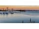 Scenic waterfront view featuring a marina, boats, and the city skyline during a vibrant sunset at 650 Golden Gate Pt # 403, Sarasota, FL 34236