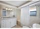 The bright bathroom features a single vanity, shower and tub combo, and tiled walls at 650 Penfield St, Longboat Key, FL 34228