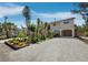 Exterior featuring stilted home with covered parking, sandy driveway, and lush landscaping in a beach community at 650 Penfield St, Longboat Key, FL 34228