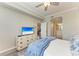 Bedroom view includes a ceiling fan, plantation shutters, and a view to the ensuite bathroom at 7019 River Hammock Dr # 104, Bradenton, FL 34212