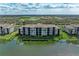 Aerial view of a building with a lake view in a lush, green community at 7019 River Hammock Dr # 104, Bradenton, FL 34212
