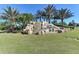 Scenic River Strand community entrance featuring a waterfall and lush landscaping at 7019 River Hammock Dr # 104, Bradenton, FL 34212