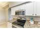 Updated kitchen showcases stainless steel appliances, granite countertops, and bright white cabinetry at 7019 River Hammock Dr # 104, Bradenton, FL 34212