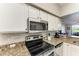 Well-equipped kitchen with granite counters, stainless steel appliances, and white cabinetry at 7019 River Hammock Dr # 104, Bradenton, FL 34212