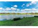 Scenic view of a calm pond and golf course surrounded by lush greenery, beneath a blue, partly cloudy sky at 7019 River Hammock Dr # 104, Bradenton, FL 34212
