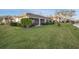 Spacious backyard with lush green lawn, mature trees, and serene water view, perfect for outdoor living at 7340 Golf Pointe Cir, Sarasota, FL 34243